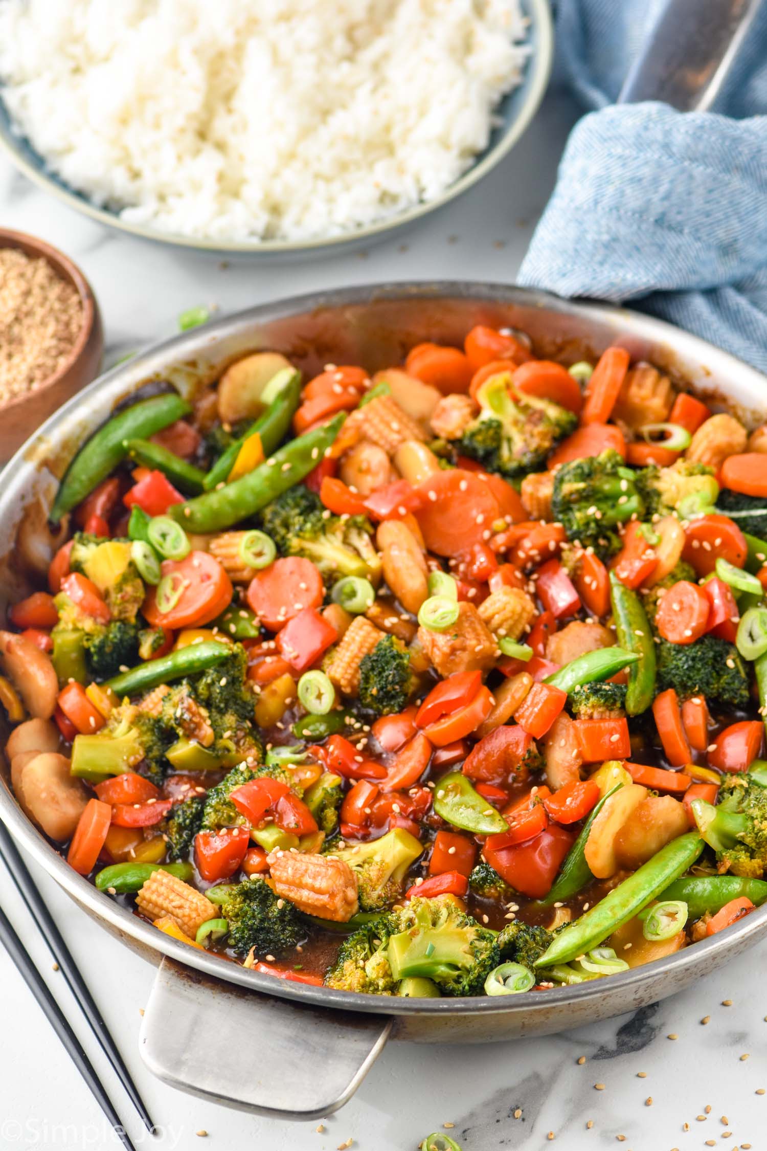 Skillet of Vegetable Stir Fry with bowl of rice beside