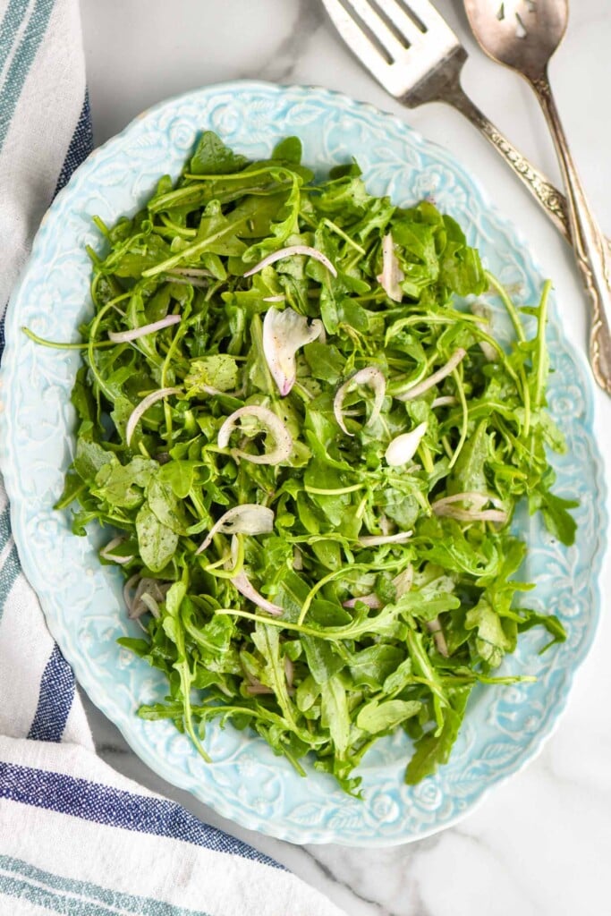 Arugula Salad with fork and spoon beside