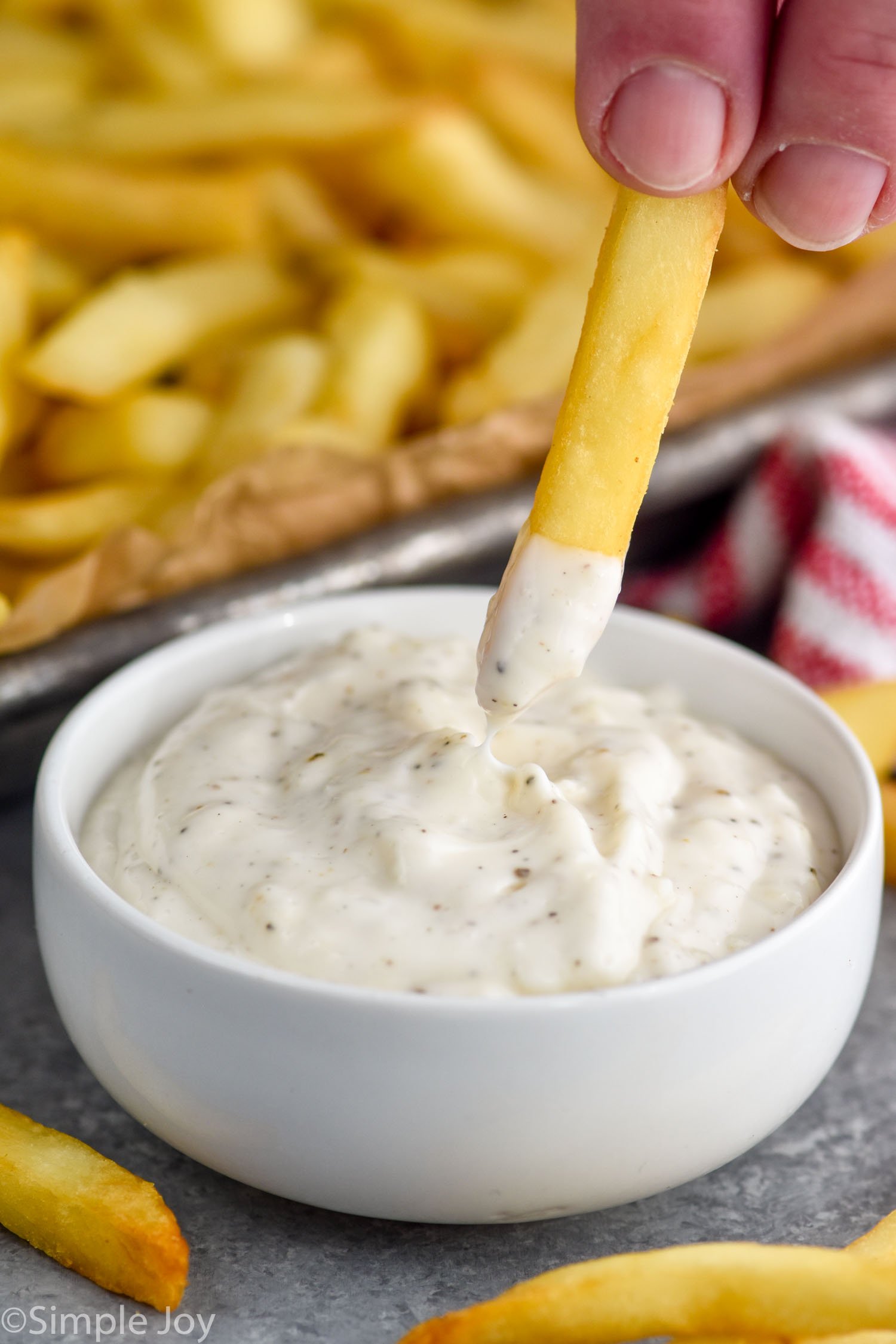 French fry dipping into dish of Garlic Aioli