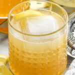 Tumbler of Gold Rush Cocktail with lemon slice and ice - 10