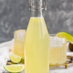 Bottle of Margarita Mix with lime slices beside