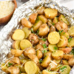 Pinterest graphic for grilled potatoes. Text says "the best grilled potatoes simplejoy.com" Image shows grilled potatoes in foil