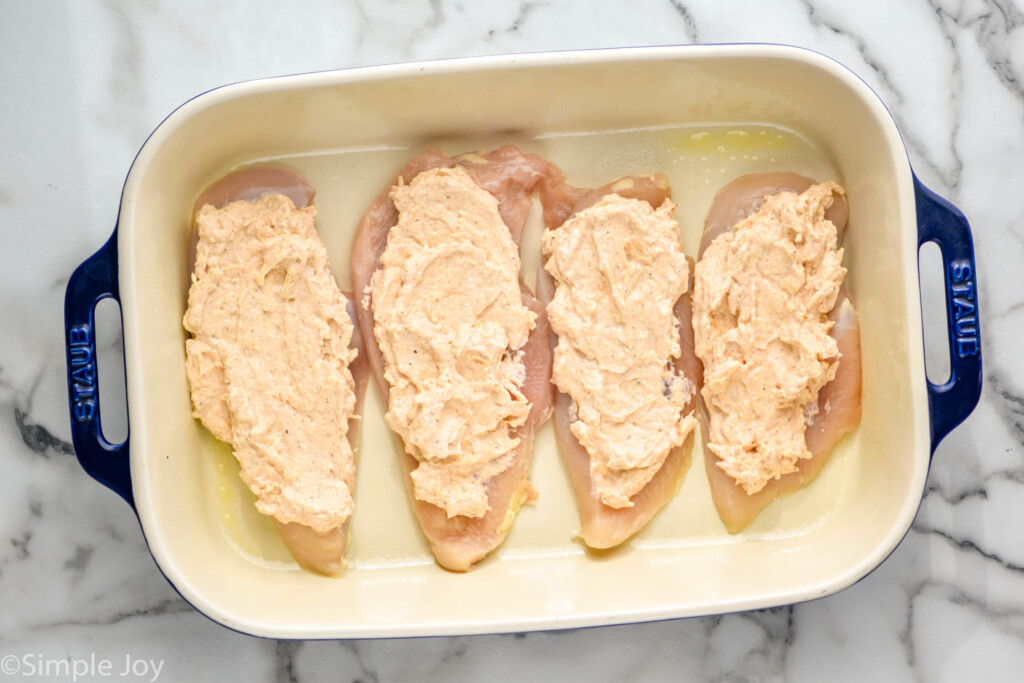 Overhead view of baking dish with chicken and ingredients for Melt In Your Mouth Chicken recipe