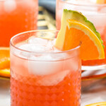 Glasses of rum punch with ice, garnished with orange slice and pineapple wedge - 12