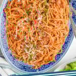 Pinterest graphic for Sausage Spaghetti recipe. Image is overhead view of plate of Sausage Spaghetti with two forks for serving. Text says, "Sausage Spaghetti simplejoy.com"