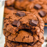 Pinterest graphic for Triple Chocolate Cookies recipe. Text says, "the best Triple Chocolate Cookies simplejoy.com." Image shows a stack of Triple Chocolate Cookies with a bite taken out of the top cookie.