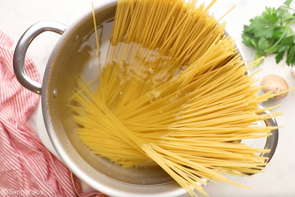 overhead of large pot of boiling water and spaghetti pasta to make Chicken Tetrazzini - 5