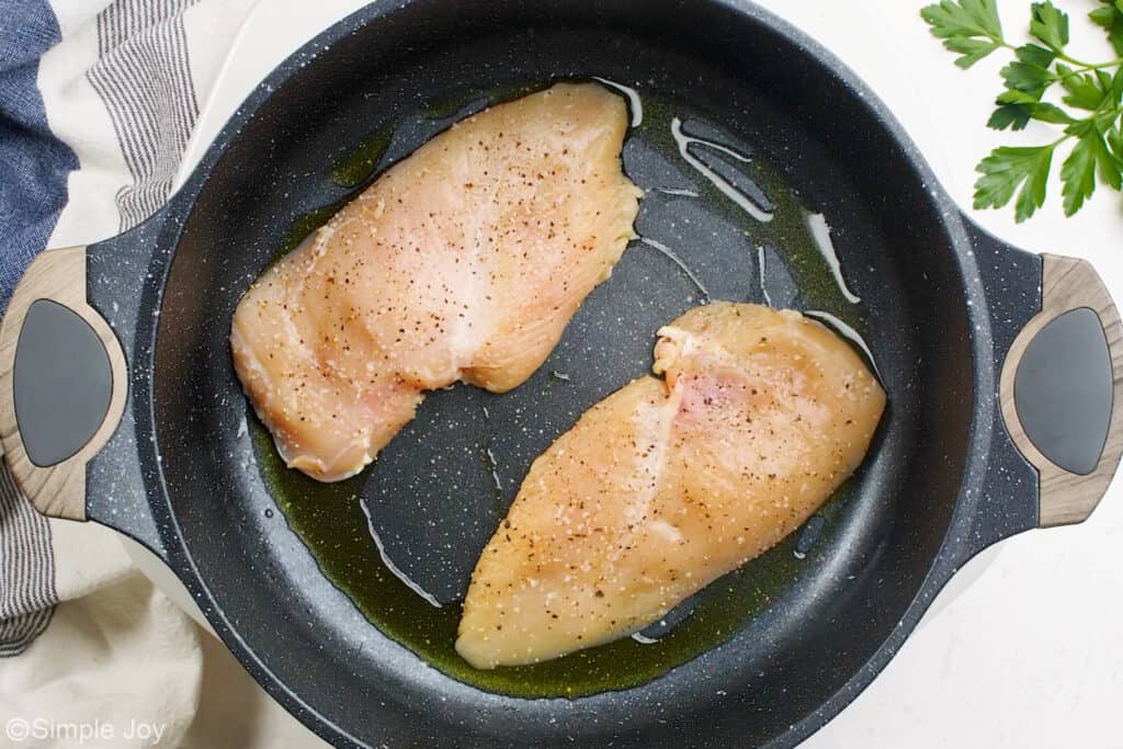 overhead of chicken cooking in a skillet