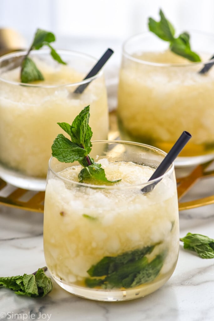 three glasses of mint julep with crushed ice, fresh mint and a straw