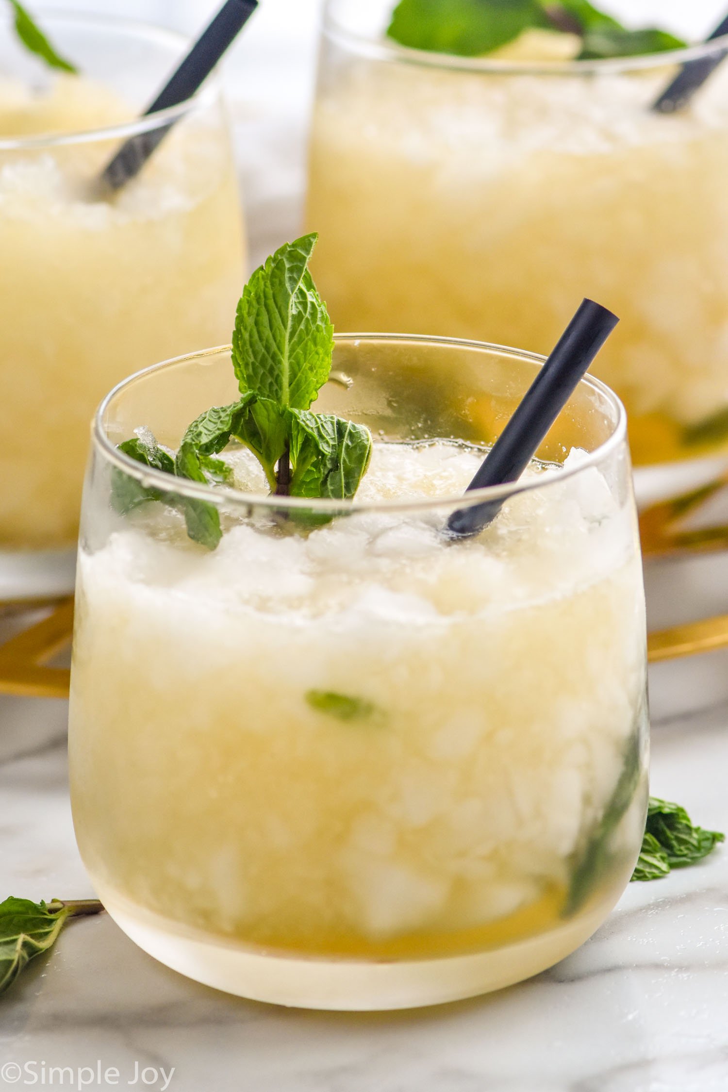 three glasses of mint julep with crushed ice, fresh mint and a straw