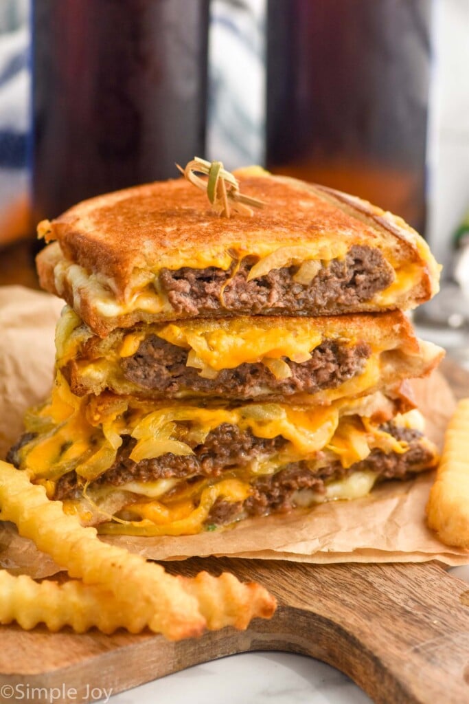 stack of patty melt sandwiches with french fries sitting in front