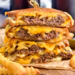 stack of patty melt sandwiches with french fries sitting in front - 8