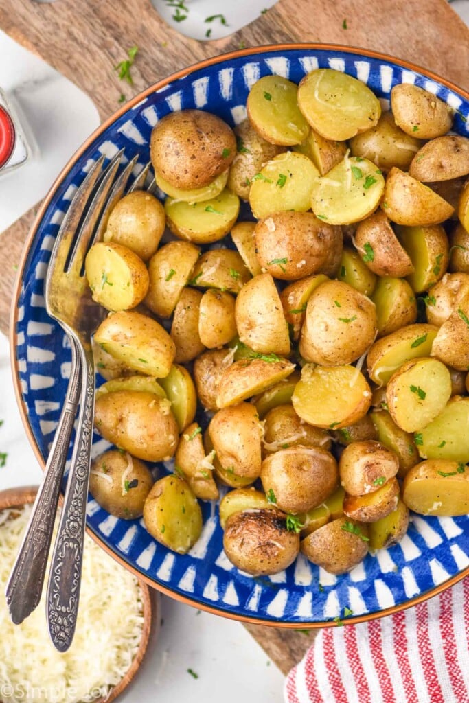 overhead of bowl of grilled potatoes with two forks for serving