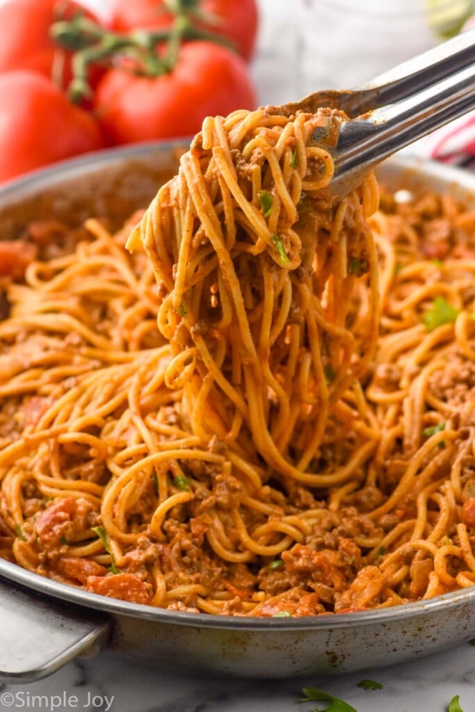 tongs pulling Taco Spaghetti out of skillet