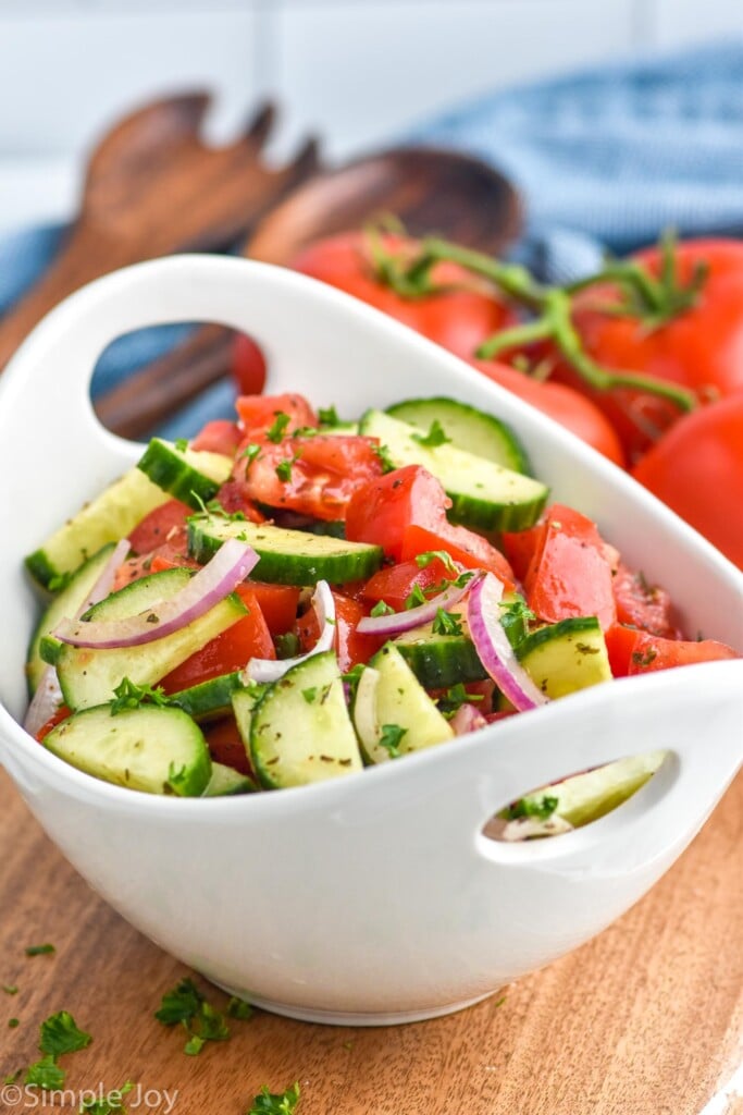 Bowl of Cucumber Tomato Salad. Vine tomatoes sitting in the background