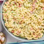 Pinterest graphic for Macaroni Salad. Image shows overhead of a large bowl of Macaroni Salad with two forks for serving. Text says "Macaroni Salad simplejoy.com"
