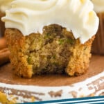 Pinterest graphic for Zucchini Cupcakes. Text says "Zucchini Cupcakes simplejoy.com" Image shows a Zucchini Cupcake with bite taken out, topped with cream cheese frosting.