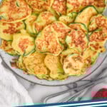 Pinterest graphic for Italian Zucchini Fritters. Image shows plate of Italian Zucchini Fritters with fresh blueberries and raspberries surrounding. Text says "zucchini fritters simplejoy.com"