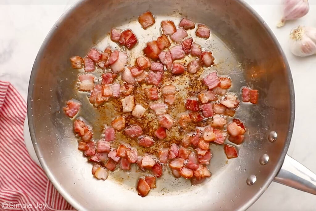 overhead of skillet of diced bacon cooking to make pasta carbonara - 8