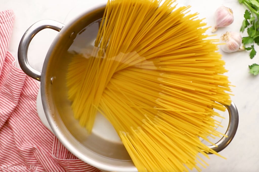 overhead of pot of boiling water with spaghetti noodles to make pasta carbonara - 7