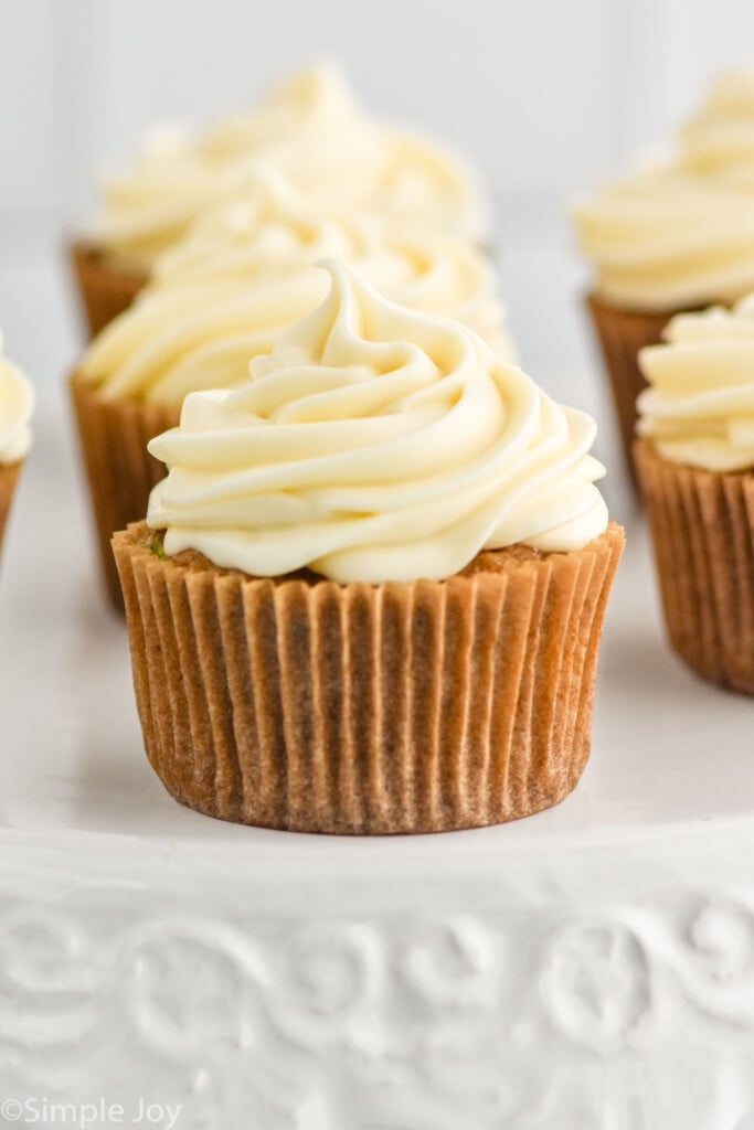 a cupcake on a cake stand with piped frosting
