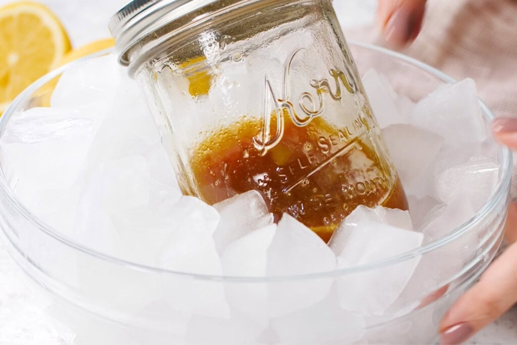 a small jar with glaze in it in a bowl of ice
