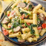 Plate of One Pot Sausage Pasta topped with freshly grated parmesan cheese and parsley with fork on the side - 11