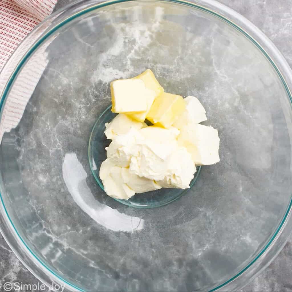 overhead of a glass bowl with cut up cream cheese and butter