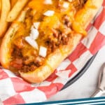 Pinterest graphic for Chili Dogs. Image shows a chili dog topped with diced onions and a side of fries. Text says "the best chili dogs simplejoy.com"