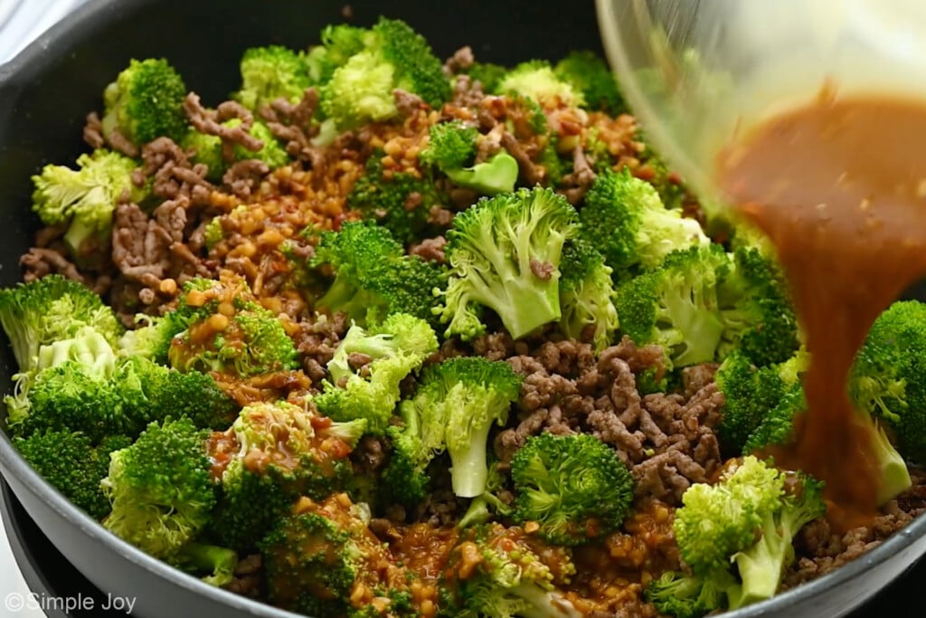 adding sauce to a skillet of beef and broccoli - 7