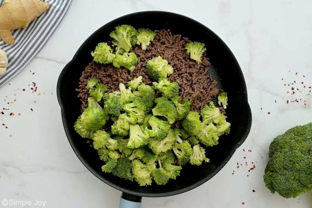 overhead of broccoli being cooked in a skillet with ground beef - 6
