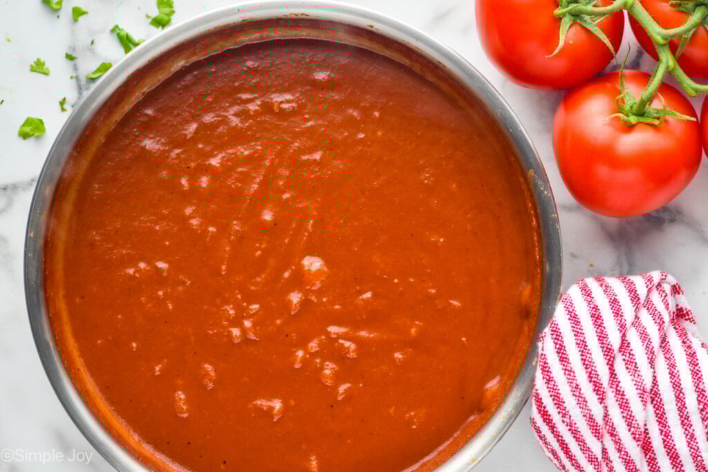 overhead of pot of homemade taco sauce with tomatoes sitting beside - 6