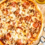 overhead of homemade Meat Lovers Pizza with two glasses of beer sitting beside - 10