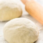 Two balls of Pizza Dough and rolling pin on flour-covered surface. - 29