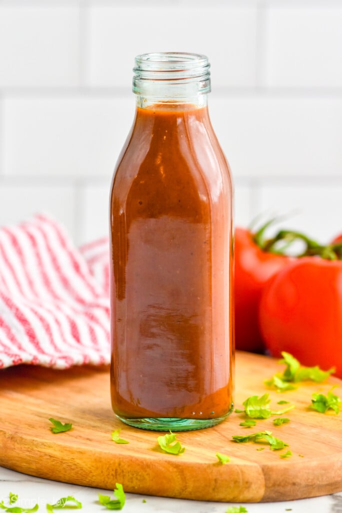 bottle of homemade Taco Sauce on a wooden board, tomatoes sitting in background - 4