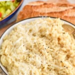 Pinterest graphic for Instant Pot Risotto. Text says "Instant Pot Risotto recipe simplejoy.com" Image shows a bowl of Instant Pot Risotto topped with black pepper and shredded parmesan cheese.