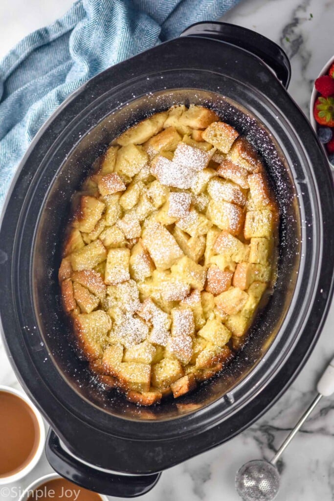 overhead of crockpot of crockpot french toast topped with powdered sugar