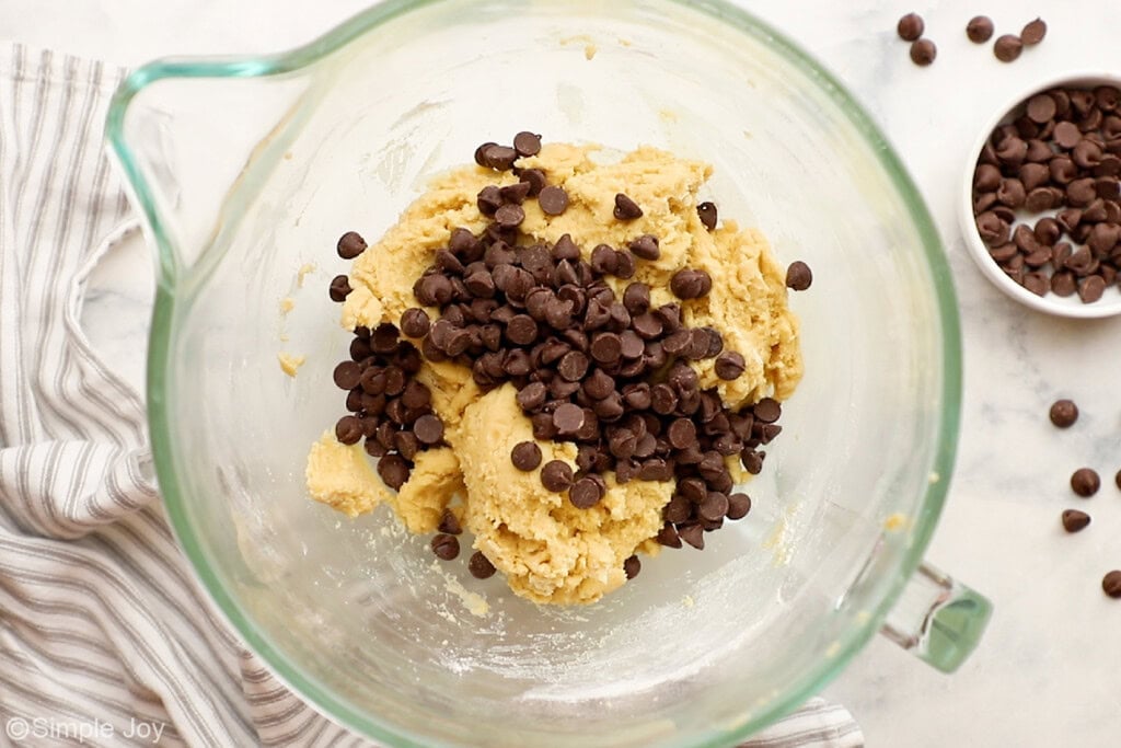 chocolate chips being added to cookie dough