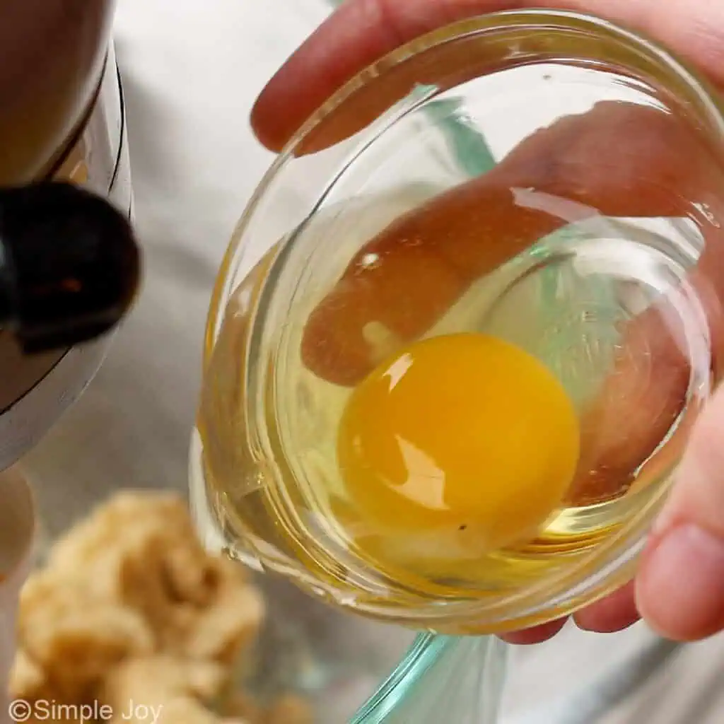 adding an egg to chocolate chip cookie batter - 7