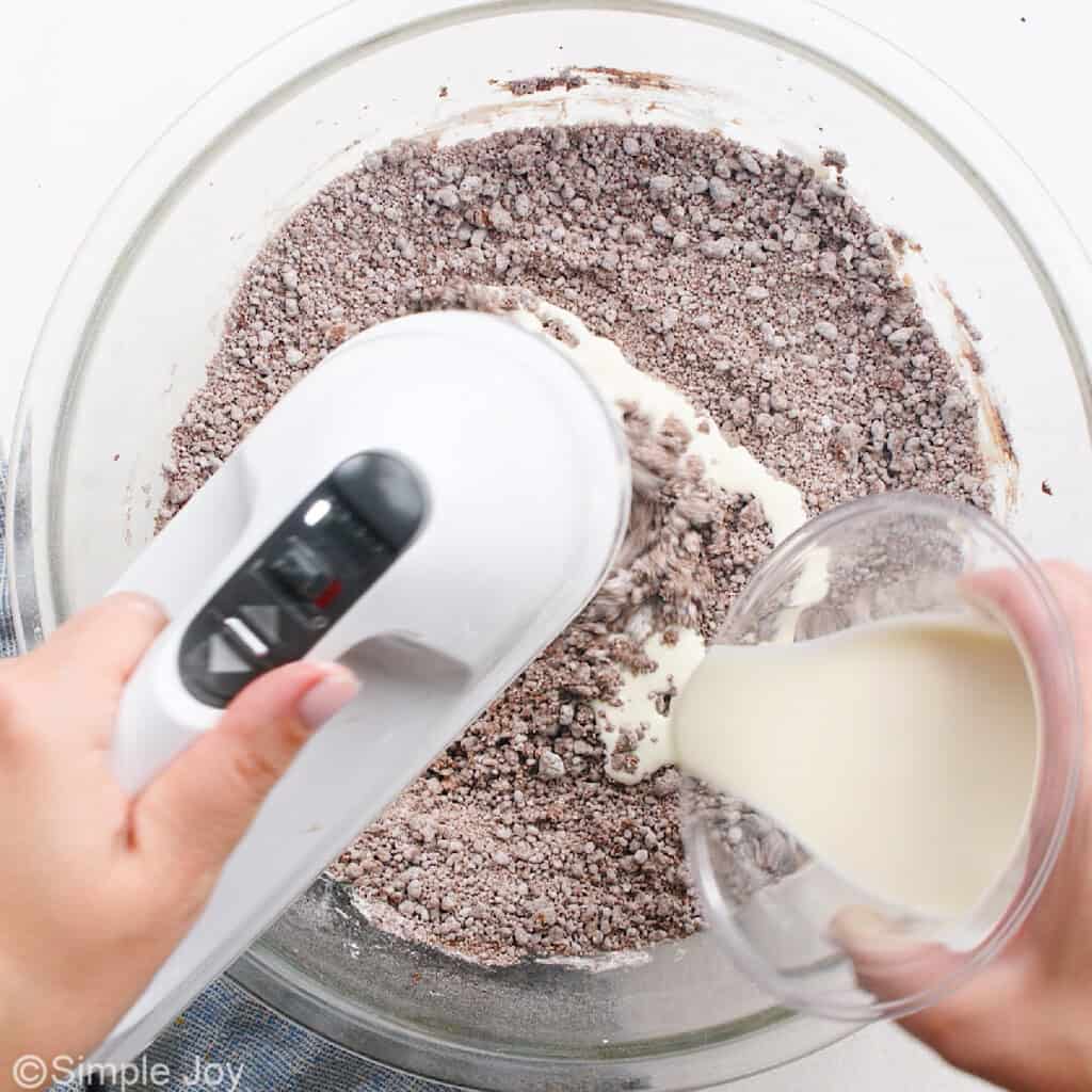 heavy cream added to a bowl to make chocolate frosting