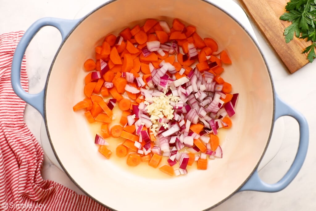 vegetables being sautéed in a large soup pot
