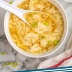 pinterest graphic of overhead of a bowl of egg drop soup with a spoon in it, says "egg drop soup simplejoy.com"