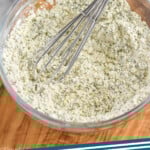 Pinterest graphic for Homemade Ranch Seasoning. Image shows a glass bowl of Homemade Ranch Seasoning with wire whisk. Says "ranch seasoning simplejoy.com"