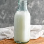 Glass bottle of Homemade Buttermilk sitting on a wooden board - 7