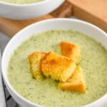 bowl of Cream of Broccoli Soup topped with croutons, bowl of Cream of Broccoli Soup and croutons sitting in background - 6
