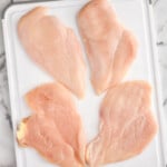 four chicken cutlets on a cutting board with a knife - 9