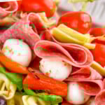 Pinterest graphic for Antipasto Skewers. Text says "the best Antipasto Skewers simplejoy.com" Image shows close up of Antipasto Skewers