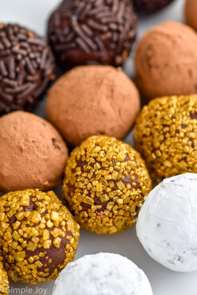 close up of chocolate truffles covered in sprinkles, cocoa powder, and powdered sugar