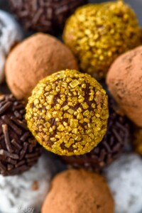 close up of chocolate truffles. Some are covered in sprinkles, powdered sugar, and cocoa powder