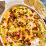 Pinterest graphic for Jalapeño Popper Dip. Says "the best Jalapeño Popper Dip simplejoy.com" Image shows dish of Jalapeño Popper Dip topped with diced bacon and green onion, tortilla chips sitting in dip and surrounding dip